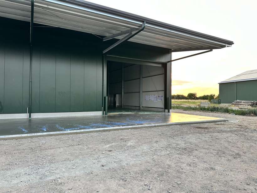 Industriehalle mit fertiger Außen-Betonfläche bei Sonnenuntergang
